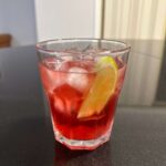 A Cape Cod or Vodka Cranberry over ice, garnished with a wedge of lime served in an old fashioned drink glass.
