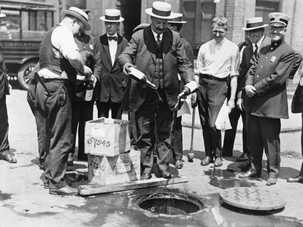 Americans tipping bottles of alcohol down the sewers as it's now illegal to possess and sell intoxicating beverages.